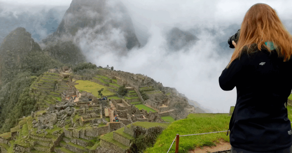 Aktualnie zwiedzając najsłynniejsze inkaskie ruiny w Peru należy zastanowić się jakie trasy zwiedzania Machu Picchu wybrać by mieć szansę zrobić klasyczne zdjęcie Machu Picchu w sposób jaki robi to turystka na zdjęciu.