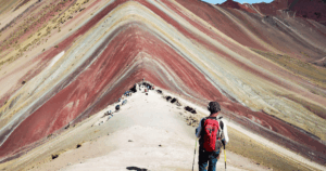 Turysta podróżujący po Peru na własną rękę idzie przez tęczowe góry Vinicunca w regionie Cusco i podziwia kolorowe góry bez tłumów turystów.